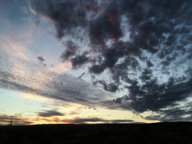 Kırsal alanda gün batımının muhteşem manzarası. Mavi mor gökyüzünde pembe mor bulutlar. Kırsalda sakin bir akşam. Büyülü atmosfer meditasyon ve rahatlama için mükemmeldir..