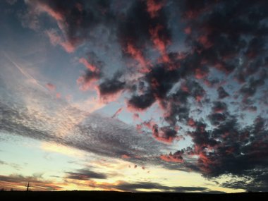 Kırsal alanda gün batımının muhteşem manzarası. Mavi mor gökyüzünde pembe mor bulutlar. Kırsalda sakin bir akşam. Büyülü atmosfer meditasyon ve rahatlama için mükemmeldir..