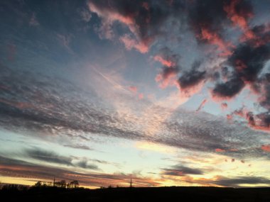 Kırsal alanda gün batımının muhteşem manzarası. Mavi mor gökyüzünde pembe mor bulutlar. Kırsalda sakin bir akşam. Büyülü atmosfer meditasyon ve rahatlama için mükemmeldir..