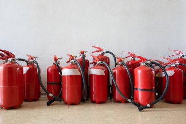 Duvarın yanında, sönmüş yangın söndürücüleri var. İşletmeler için yangın söndürücülerin yenilenmesi.