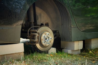 Dışarıdaki tuğlalarla arabayı kapatın. Çalıntı araç tekerleği kavramı. Tekerleği olmayan araba..