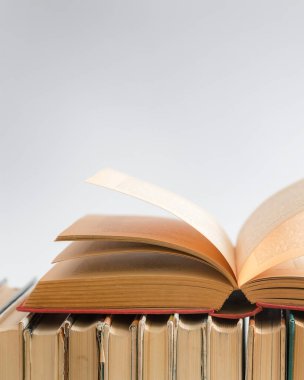 Beyaz arka plan üzerine açık bir kitap, ahşap masa üzerine sert ciltli kitaplar. Eğitim ve öğrenim geçmişi. Okula dönüyorum, ders çalışıyorum. Metin için alanı kopyala