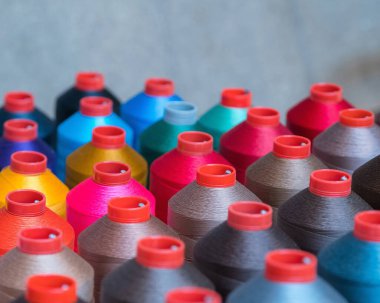 Giyim endüstrisinde kullanılan renkli işlemeli iplik makarası, çok renkli iplik ruloları, pazarda dikiş malzemeleri satışı