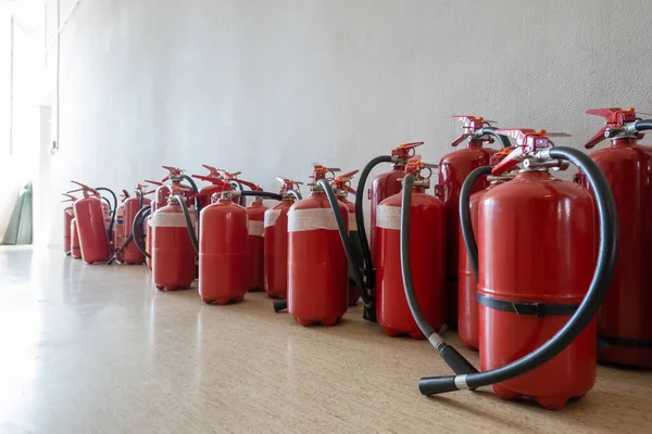 壁の横の床に期限切れの消火器の束 事業用消火器の更新 — ストック写真