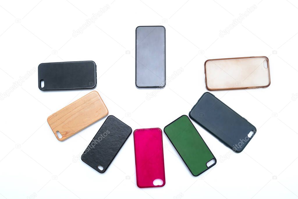 Pile of multicolored plastic back covers for mobile phone on white background. Choice of smart phone protector accessories. A lot of silicone phone backs or skins next to smart phone