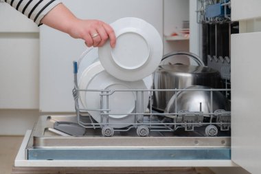 Mutfakta bulaşık makinesini elden boşalt. Bulaşık makinesinin tüm malzemelerini alan kişi....