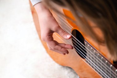 El kamerasıyla akustik gitar çal. Klasik müzik enstrümanı üzerinde çalışıyorum. Ev okulu eğitimi