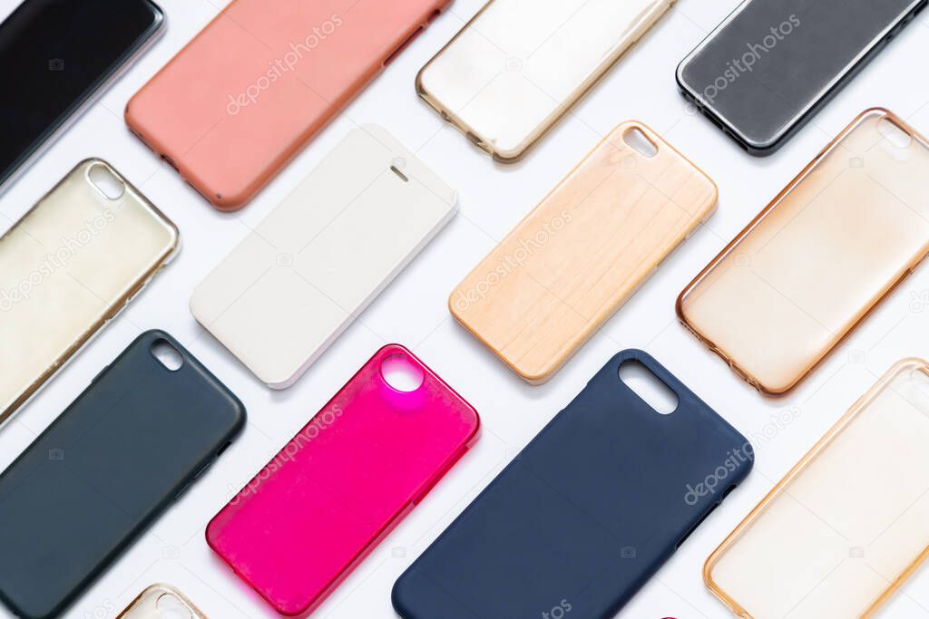 Pile of multicolored plastic back covers for mobile phone. Choice of smart phone protector accessories on white background. A lot of silicone phone backs or skins next to each other