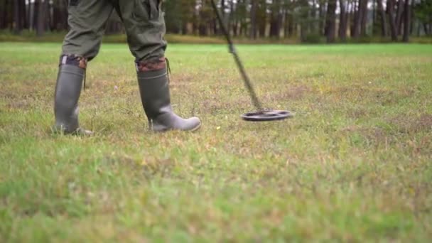 Çimlerin Üzerinde Metal Dedektörüyle Hazine Avcılığı Yapan Çizmeli Bir Adam — Stok video