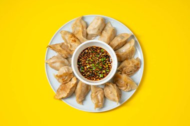Sarı arka planda baharatlı soya soslu kızarmış gyoza usulü hamur köftesi. Asya yemeklerini götür..
