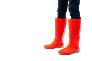 Beyaz arka planda izole edilmiş kırmızı lastik ayakkabılı kadın bacaklarını kapatın. Yağmur mevsimi hava tahmini.