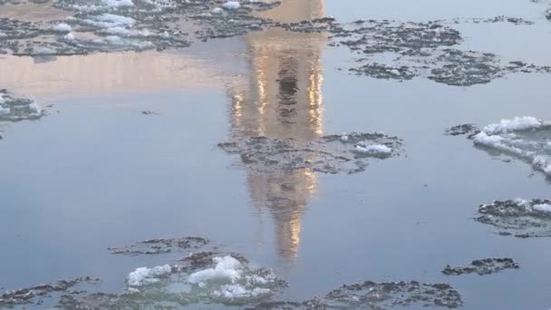 冬の川の流れにおける教会の反射の要約ビュー 市内の流氷 水面に映る都市建築 — ストック動画