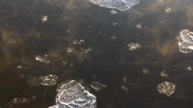 Sisli bir sabahta eriyen buzlar nehirden aşağı akıyor. Kışın sonunda sisli su yüzeyi. Buz kayması. 