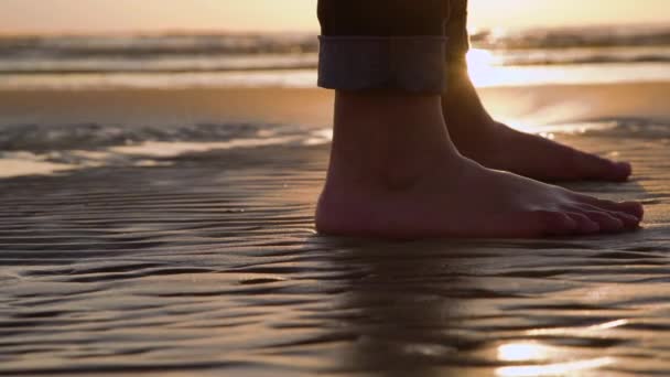 Nahaufnahme Von Frauenbeinen Jeans Die Bei Sonnenuntergang Sandstrand Stehen Nahaufnahme — Stockvideo