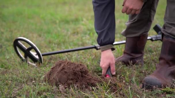 Çimlerin Üzerinde Metal Dedektörüyle Hazine Avcılığı Yapan Çizmeli Bir Adam — Stok video