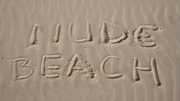 Крупним Планом Жінка Кидає Бюстгальтер Знак Оголеного Пляжу Написаний Піску — стокове відео
