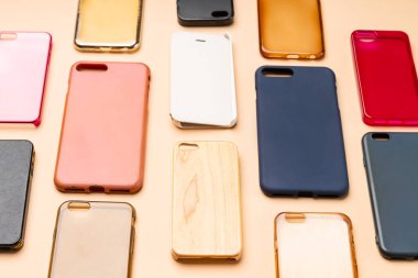 Cep telefonu için çok renkli plastik kapaklar yığını. Tarafsız bir arkaplanda akıllı telefon koruyucusu aksesuarları. Bir sürü silikon telefon ve deri yan yana.