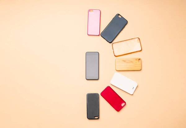 Выбор многоцветных пластиковых задней крышки для мобильных телефонов на нейтральном фоне со смартфоном на стороне