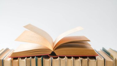 Beyaz arka plan üzerine açık bir kitap, ahşap masa üzerine sert ciltli kitaplar. Eğitim ve öğrenim geçmişi. Okula dönüyorum, ders çalışıyorum. Metin için alanı kopyala