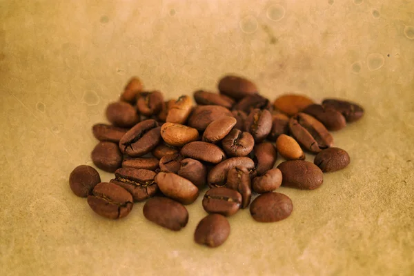 咖啡豆在旧木桌上。胶片颗粒的影响. — 图库照片