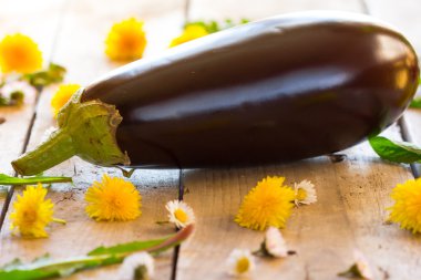 Bahar çiçekleri ile ahşap bir masa üzerinde patlıcan