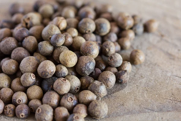 Allspice em uma mesa de madeira velha — Fotografia de Stock