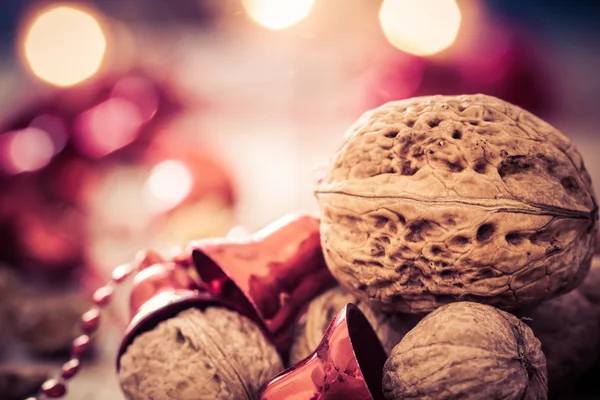 Kerstmis achtergrond met walnoten, rode klokken en kaarsen. — Stockfoto