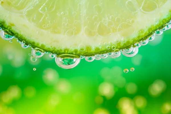 Green lime with water splash — Stock Photo, Image
