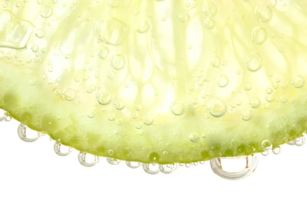 Zielone limonki z plusk wody. Na białym tle — Zdjęcie stockowe