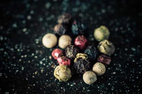 Colored pepper on a black marble slab