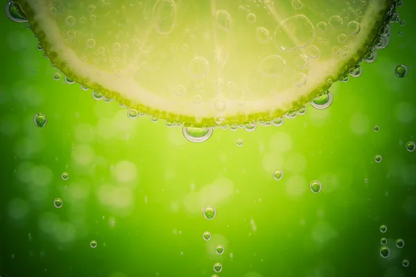 Green lime with water splash — Stock Photo, Image