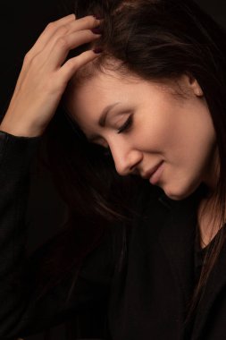 Genç bir kadının saçını düzleştirmeyi düşündüğü dikey bir stüdyo çekimi. Esmerin fotokopi alanı ile yakın plan portresi. Aşağı bak..