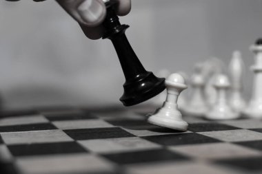 Satranç oyunu. Kral bir piyonu devirir..