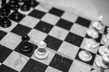 Eski bir satranç tahtasında eski bir satranç. Siyah beyaz fotoğraf. Yüzleşme oyunu.