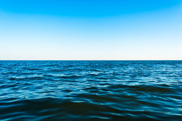 Маленькие морские волны на фоне голубого неба и белых шляпок.