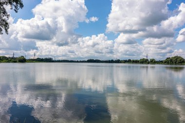 Şehrin eteklerinde geniş bir nehir beyaz bulutlar sergiliyor..
