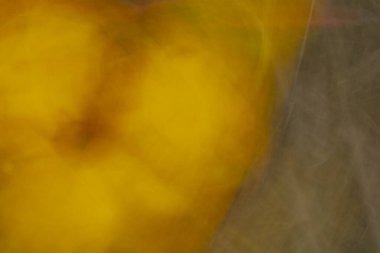 Sebze bahçesindeki kabak ve kuru yaprakların soyut bulanık arkaplanı. Sarı ve kahverengi sonbahar tonlarında fon.