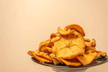 Tabakta kurutulmuş meyve. Sıcak bir arka planda kesilmiş kuru elmalar..