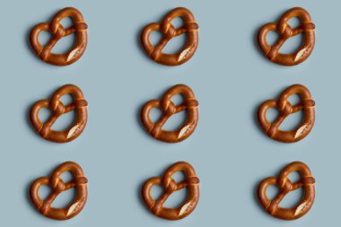 Mavi arka planda pişmiş taze kraker deseni. Manzara, düzlük, festival yemekleri konsepti. Minimum arkaplanda tuzlu kraker