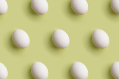 Açık yeşil arka planda beyaz yumurta deseni. Üst görünüm, düz görünüm, modern kartlar için en düşük arkaplan