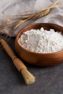 Ahşap bardakta un ve arka planda mutfak malzemeleri. Pasta yiyeceği kavramı