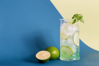 Minimum mavi ve sarı arkaplanlı buzlu limon mojito.