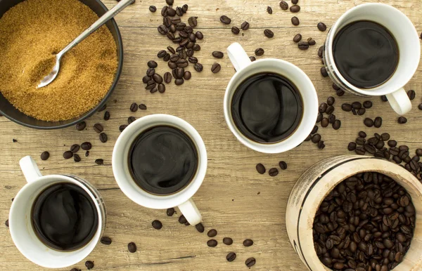 4 Черный кофе с бобами и сахаром на деревянной суфракии от Абова Стоковая Картинка