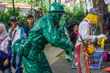 Kuala Lumpur, Malezya - 24 Mart 2019: Yeşil asker olarak sokak sanatçısı