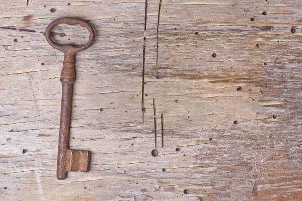 Einzelschlüssel auf einem alten Holztisch — Stockfoto