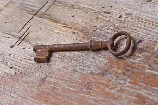 Einzelschlüssel auf einem alten Holztisch — Stockfoto