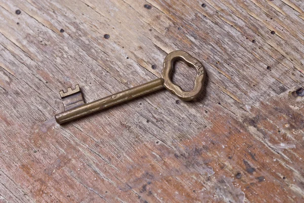 Einzelschlüssel auf einem alten Holztisch — Stockfoto
