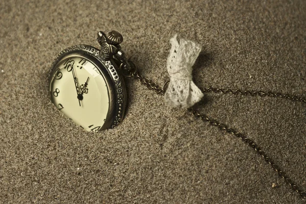 Reloj antiguo en la arena —  Fotos de Stock