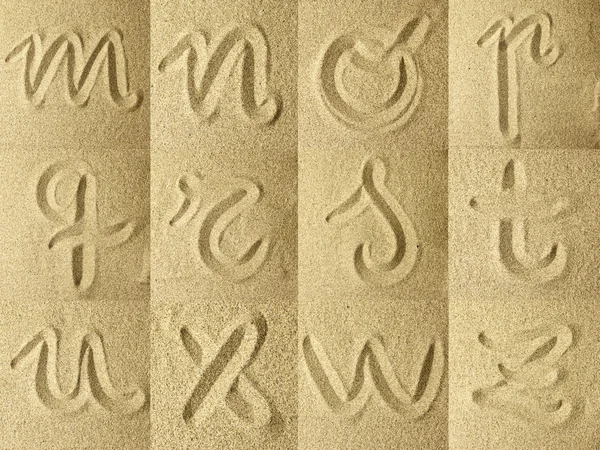 Alphabet manuscrit dans le sable — Photo