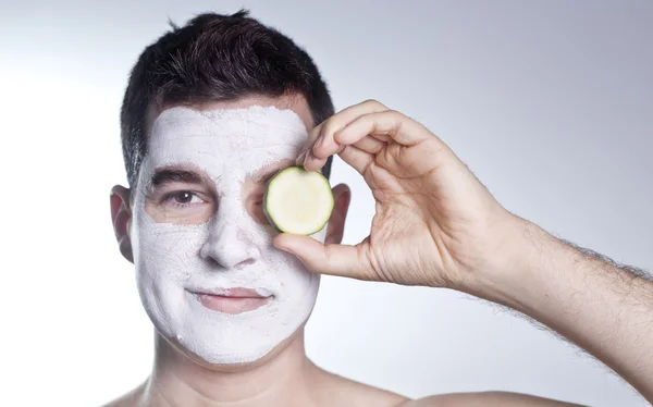 Hombre guapo con máscara facial de arcilla en spa de belleza —  Fotos de Stock